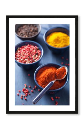 spices in bowls: curry, pink black pepper, paprika powder