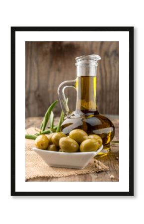 Olive oil and olive branch on the wooden table
