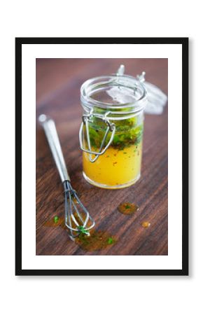 Salad dressing with olive oil chili and herbs in a glass jar