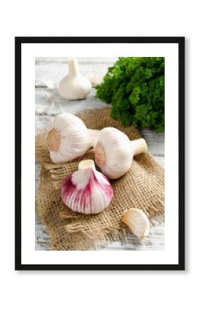 Garlic and a bunch of parsley on a white table