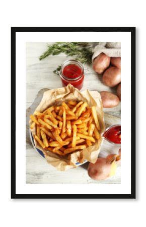 Tasty french fries on cutting board, on wooden table background