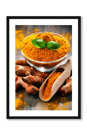 Composition with bowl of turmeric powder on wooden table