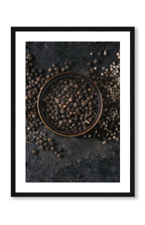 Variety of different black peppers allspice, pimento, monks pepper, peppercorns in tin can over old black iron texture background. Top view, copy space.