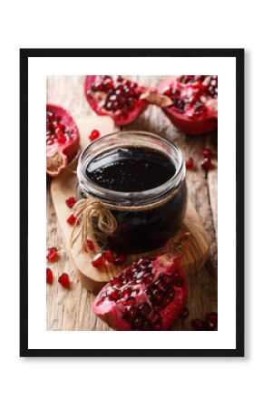 Homemade pomegranate sauce narsharab in a glass jar close-up. vertical