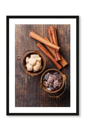 Cinnamon sticks and brown sugar on wooden background