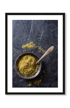 Mixed east spice - zaatar or zatar in metal vintage bowl on dark stone background. Selective focus. Top view
