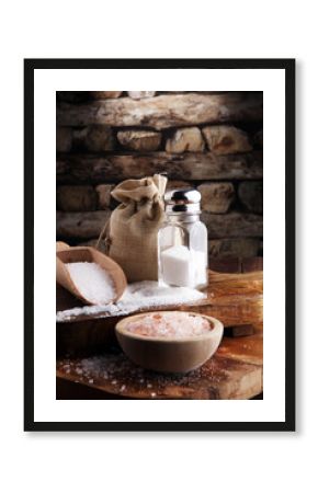 Salt Shaker and salt on wooden table.