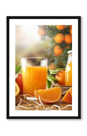 Glass of orange juice on a wooden in field vertical