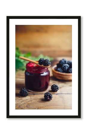 Fresh homemade blackberry jam in glass jar on a wooden background  