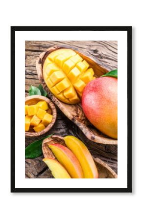 Mango fruit and mango cubes on the wooden table.
