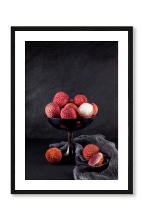 ripe, vermilion exotic lichees decorated on a slate plate kitchen table background with napkin