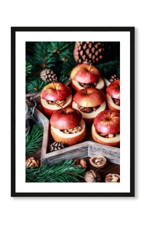 Baked apples with cinnamon on rustic background. Autumn or winter dessert. Closeup photo of a tasty baked apples with christmas decoration