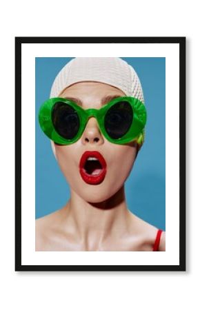 A large portrait of a shocked swimmer in a swimming cap on a blue background. Cool banner
