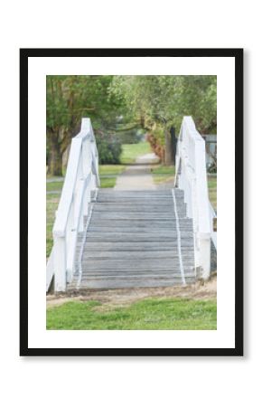 A wooden foot bridge leading onto a footpath.