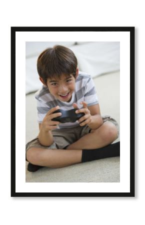 Smiling mixed race boy playing video game